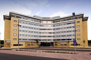 A modern building with a curved facade, multiple windows, and a sign for Costa. - Premier Inn Manchester Airport - M56/J6 Runger Lane North (Manchester)