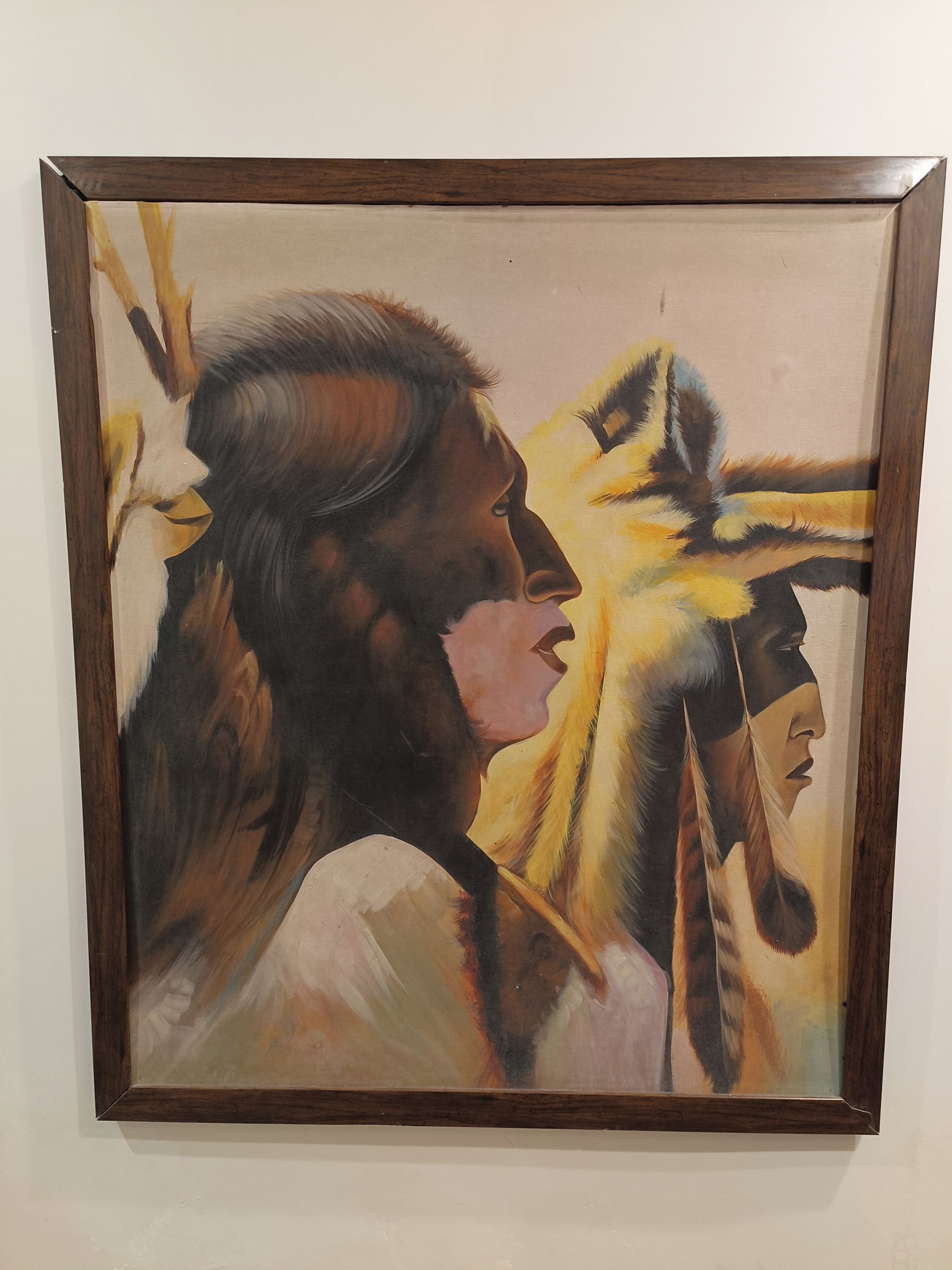A framed painting of a Native American figure with a feathered headdress.
