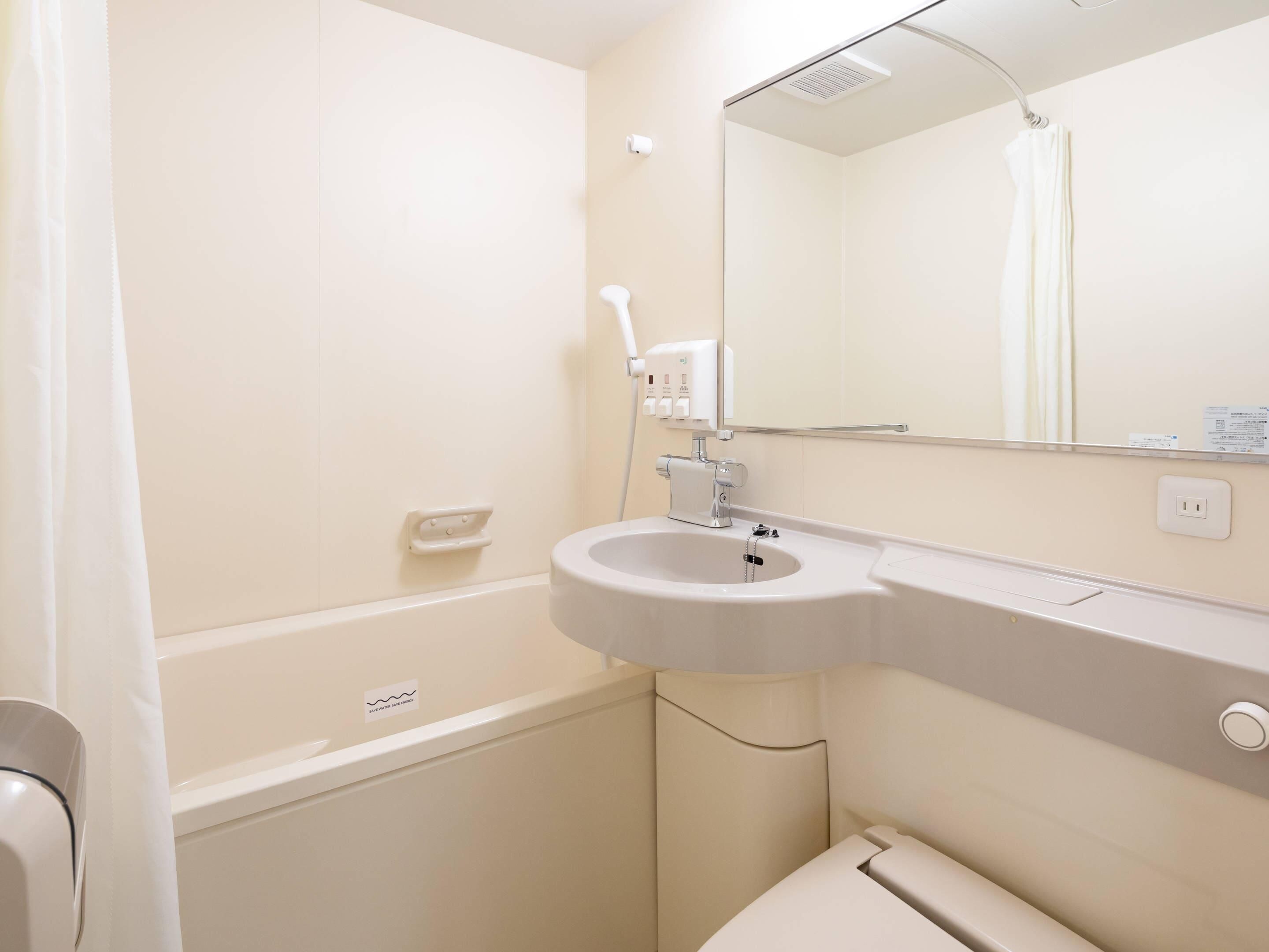 A bathroom with a sink, mirror, and shower.