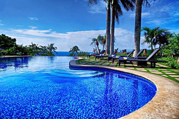Una piscina al aire libre, sillones reclinables de piscina