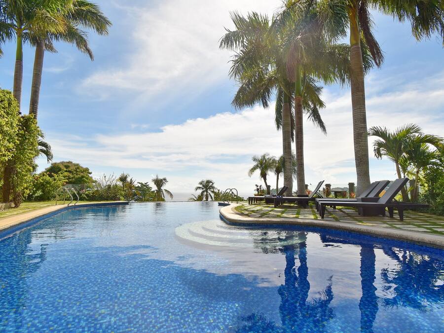 Una piscina al aire libre, sillones reclinables de piscina