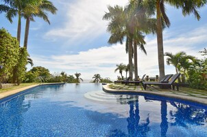 Una piscina al aire libre, sillones reclinables de piscina