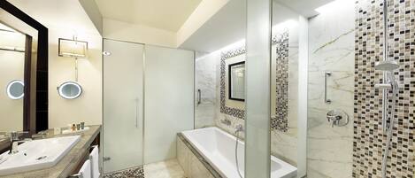 A modern bathroom with a large mirror, a bathtub, and a shower area.