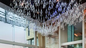 A modern lobby with a glass ceiling, a reception desk, and a seating area with a patterned floor. - Hilton Windhoek (Windhoek)