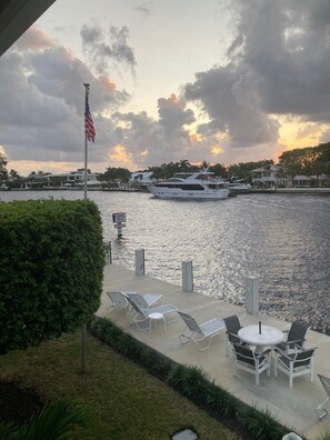 A waterfront patio with lounge chairs and a flagpole. - Holiday Isle Yacht Club (Fort Lauderdale)