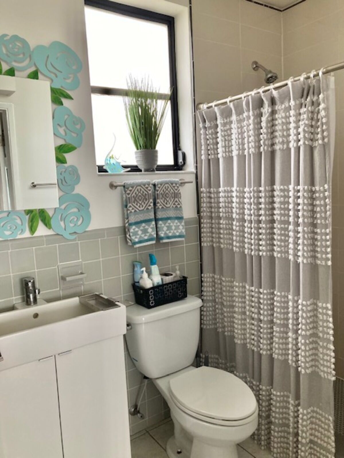 A bathroom with a toilet, sink, and shower curtain.