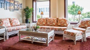 Una habitación con un conjunto de sofás, una mesa de centro y una planta en maceta.