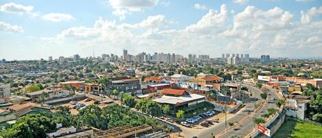 A cityscape with a mix of residential and commercial buildings, a main road, and a clear sky.