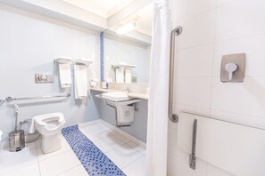 A modern bathroom with a white toilet, a sink, and a shower area. - Hotel Inter Cuiabá (Cuiabá)