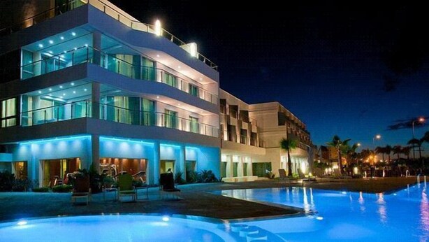 Een modern hotel met een zwembad in de nacht.