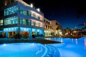 Un hotel moderno con piscina por la noche.