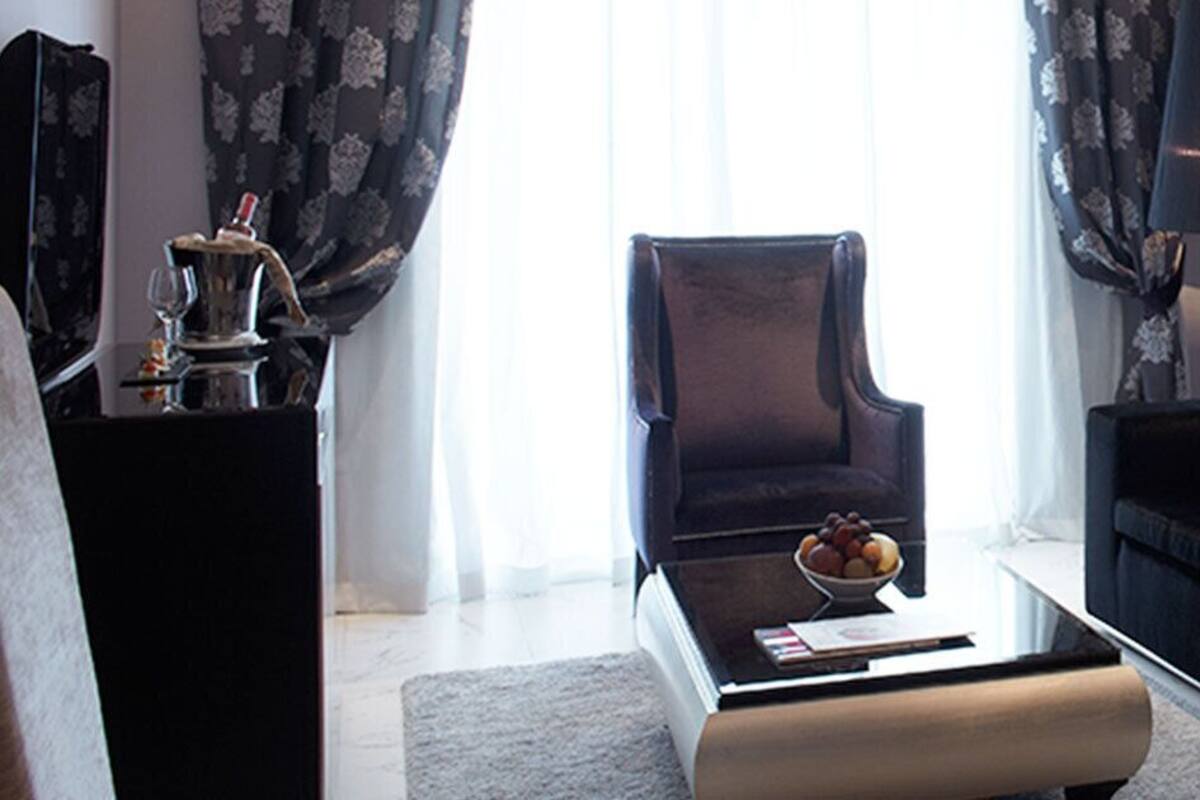 Un salon moderne avec un canapé foncé, une table basse ronde et un vase de fleurs.