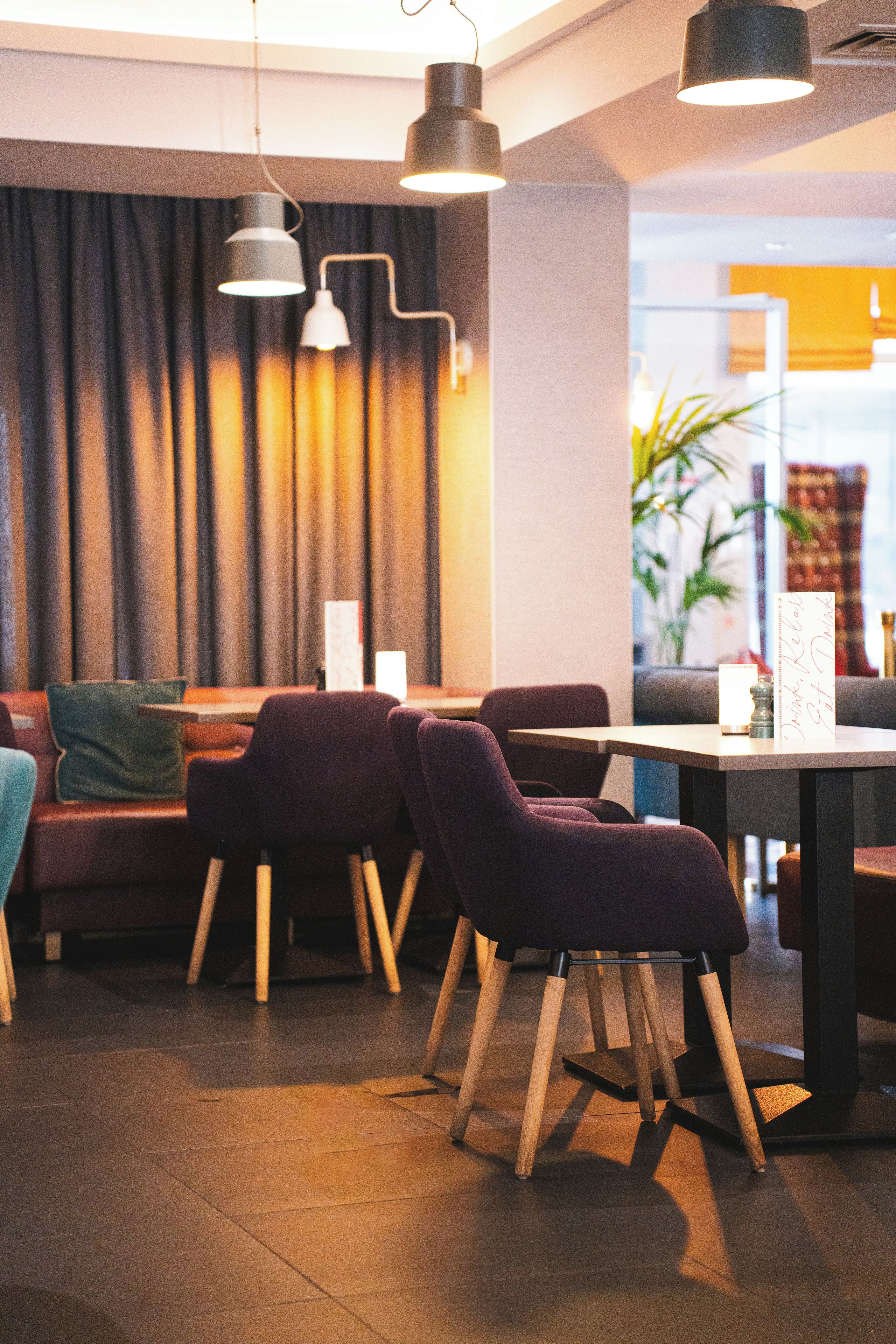 A modern interior with a seating area featuring sofas and chairs, a table, and pendant lighting.