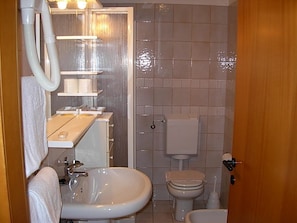 Ein Badezimmer mit Waschbecken, Toilette und Duschbereich.