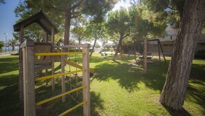 Une aire de jeux avec des structures en bois et des barres de sécurité jaunes.