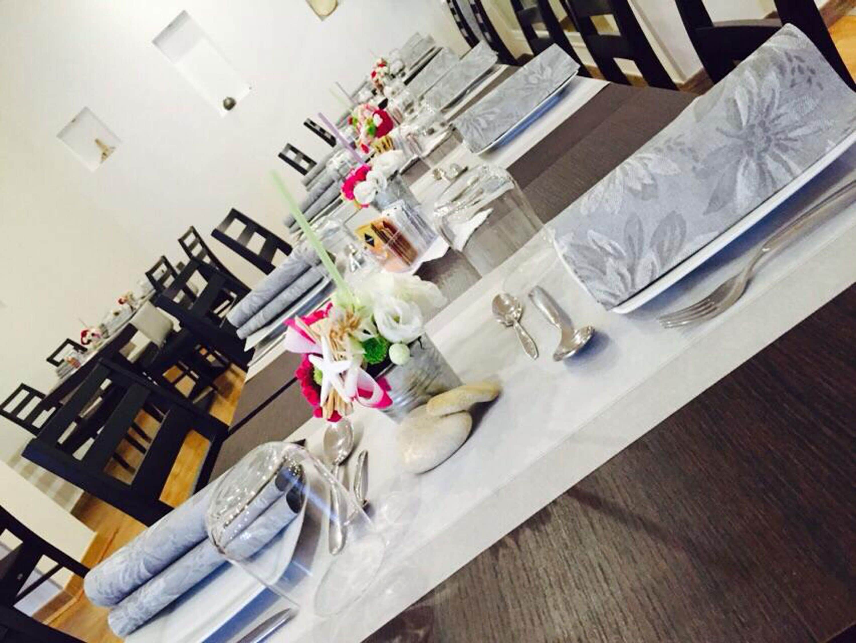 A dining area with tables set for a meal, chairs, and a decorative centerpiece.