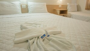 A hotel room with a large bed, two bedside tables, and a nightstand.