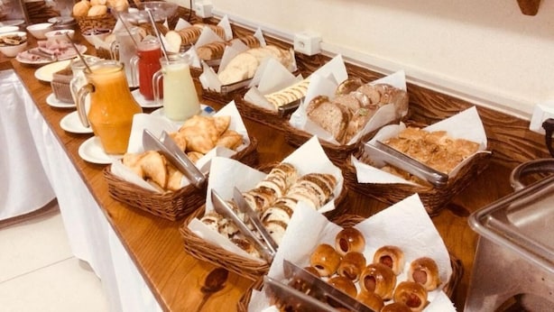 A buffet table with various food items and utensils.