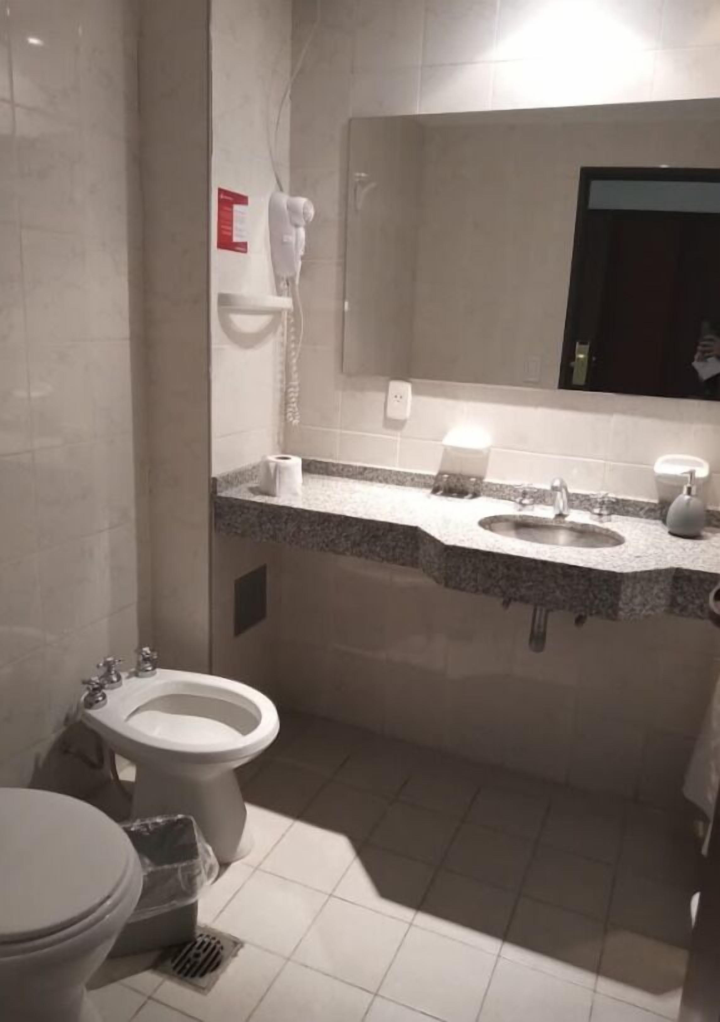 Un bagno con servizi igienici, bidet, lavandino e specchio.