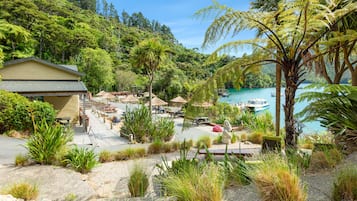 A resort with outdoor seating, a pool, and a view of the water.