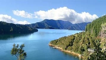 A lake surrounded by mountains with a house on the right.