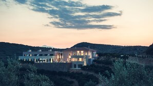 A modern house with multiple levels and a large balcony, surrounded by hills and olive trees. - Perivoli Country Hotel & Retreat (Nafplio)