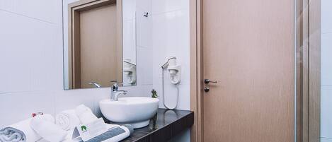 Een moderne badkamer met een grote spiegel, een wastafel en een douchehoek.