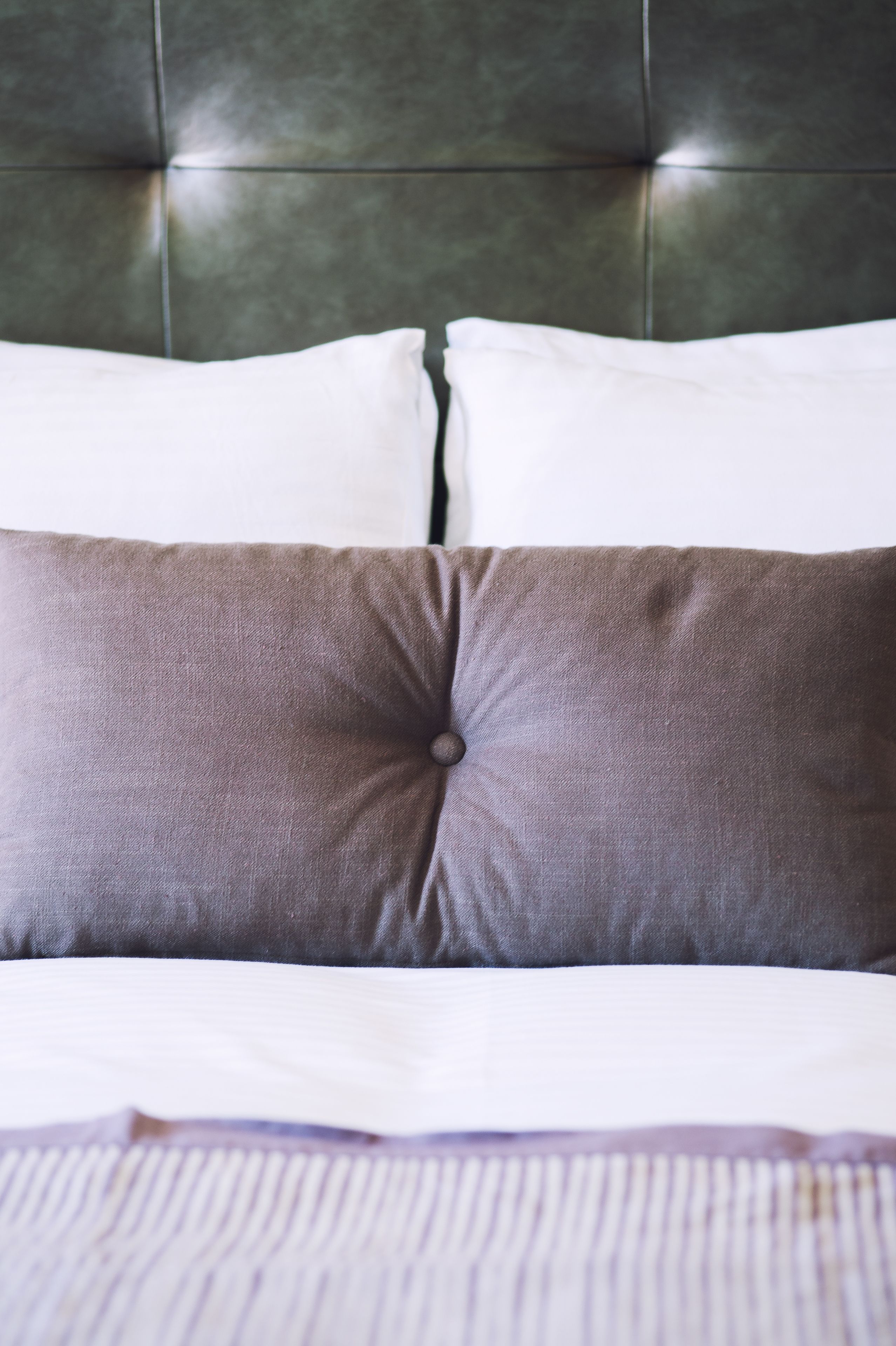 A bed with a tufted headboard and two pillows.