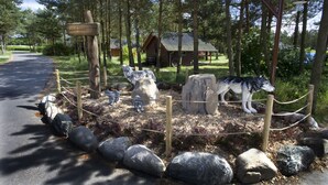 A fenced area with wolf sculptures and a wooden sign. - Legoland Holiday Village (Billund)
