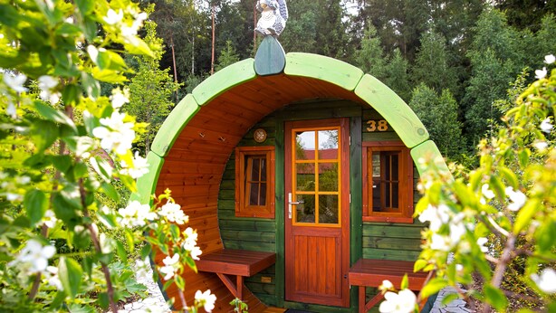 A wooden cabin with a green roof, a wooden door, and two windows. - Legoland Holiday Village (Billund)