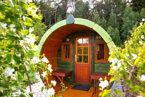 A wooden cabin with a green roof, a wooden door, and two windows. - Legoland Holiday Village (Billund)