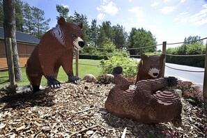 A LEGO sculpture of a bear and a fox in a garden setting. - Legoland Holiday Village (Billund)