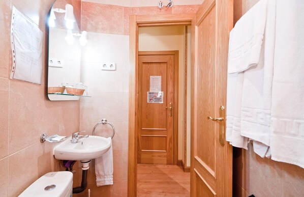 A bathroom with a sink, mirror, and towel rack.