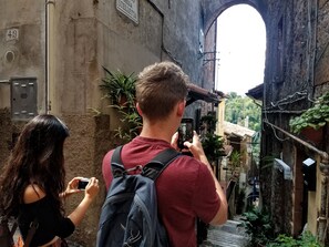A narrow alleyway with a rustic stone wall, a metal door, and a sign reading "Stella". - WIKI HOSTEL Colive - Adults Only & Pet Friendly (Zagarolo)