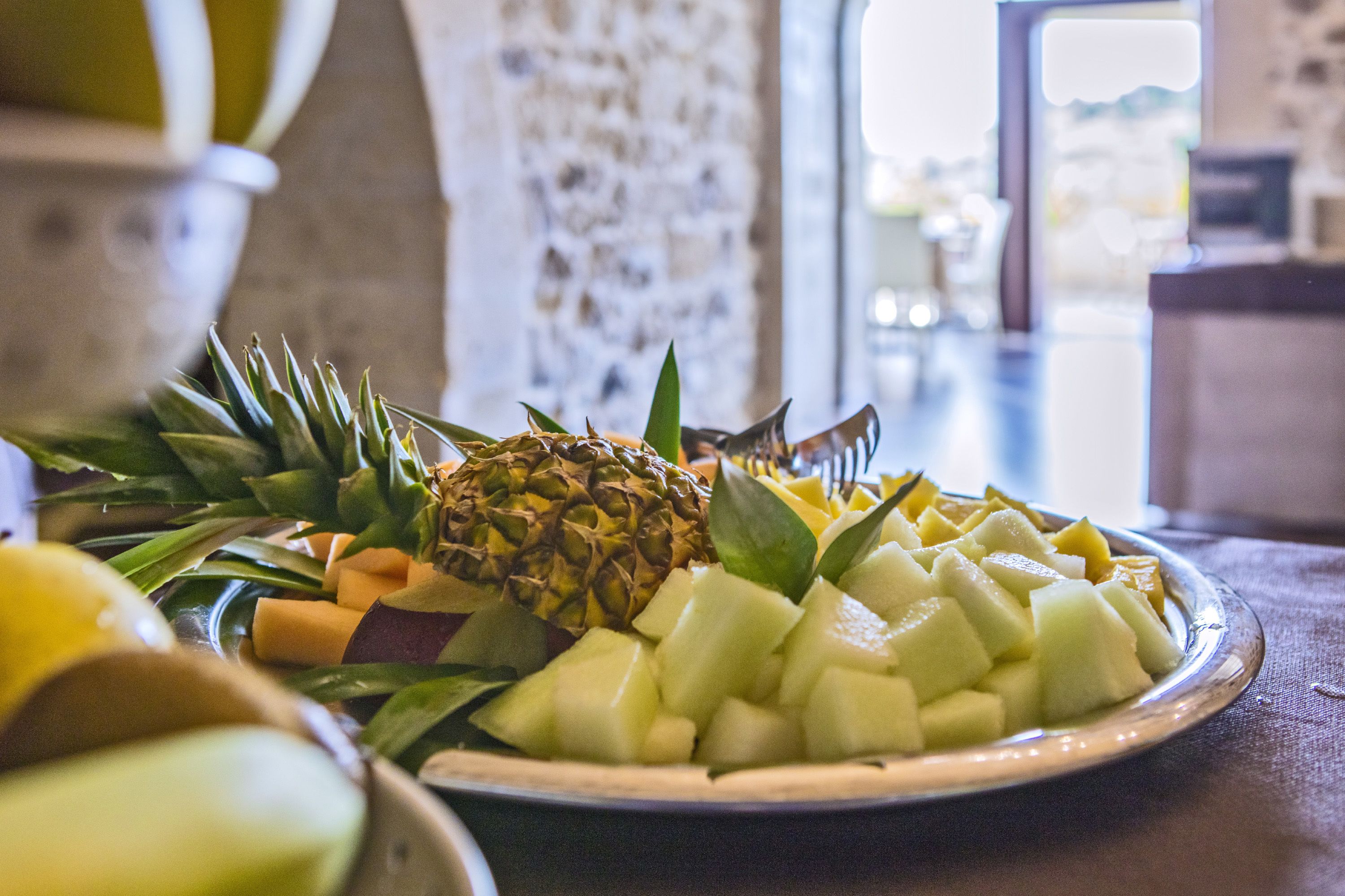 A fruit platter with pineapple, melon, and banana on a table.