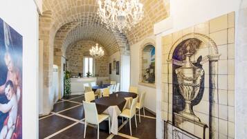 Enjoy meals in this stylish dining area with a high arched ceiling, elegant chandelier, and comfortable seating.