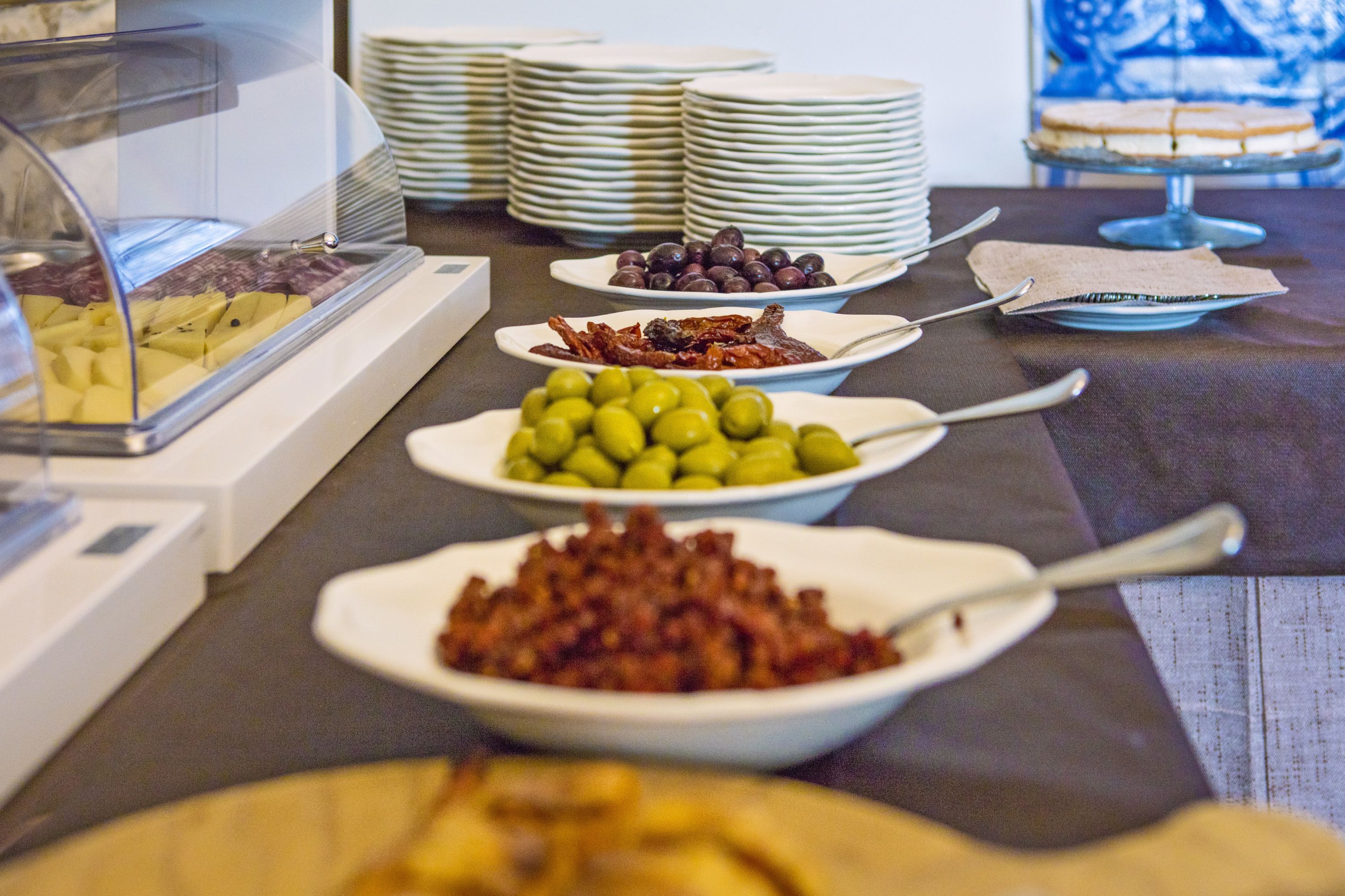 Un buffet proposant une variété de plats, notamment des fruits, des olives et des viandes.