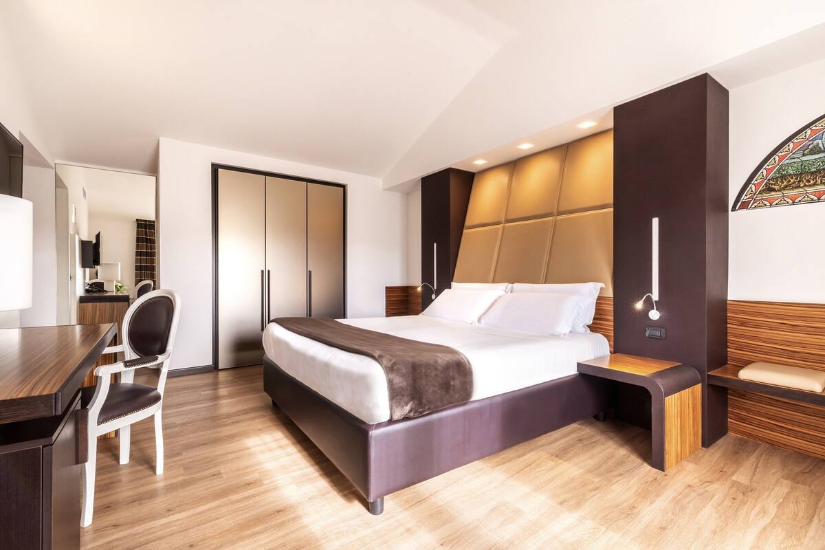 Une chambre à coucher moderne avec un grand lit, un bureau et une chaise.