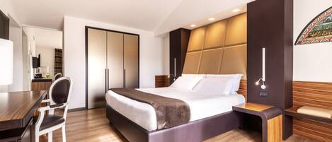 A modern bedroom with a large bed, a desk, and a chair.