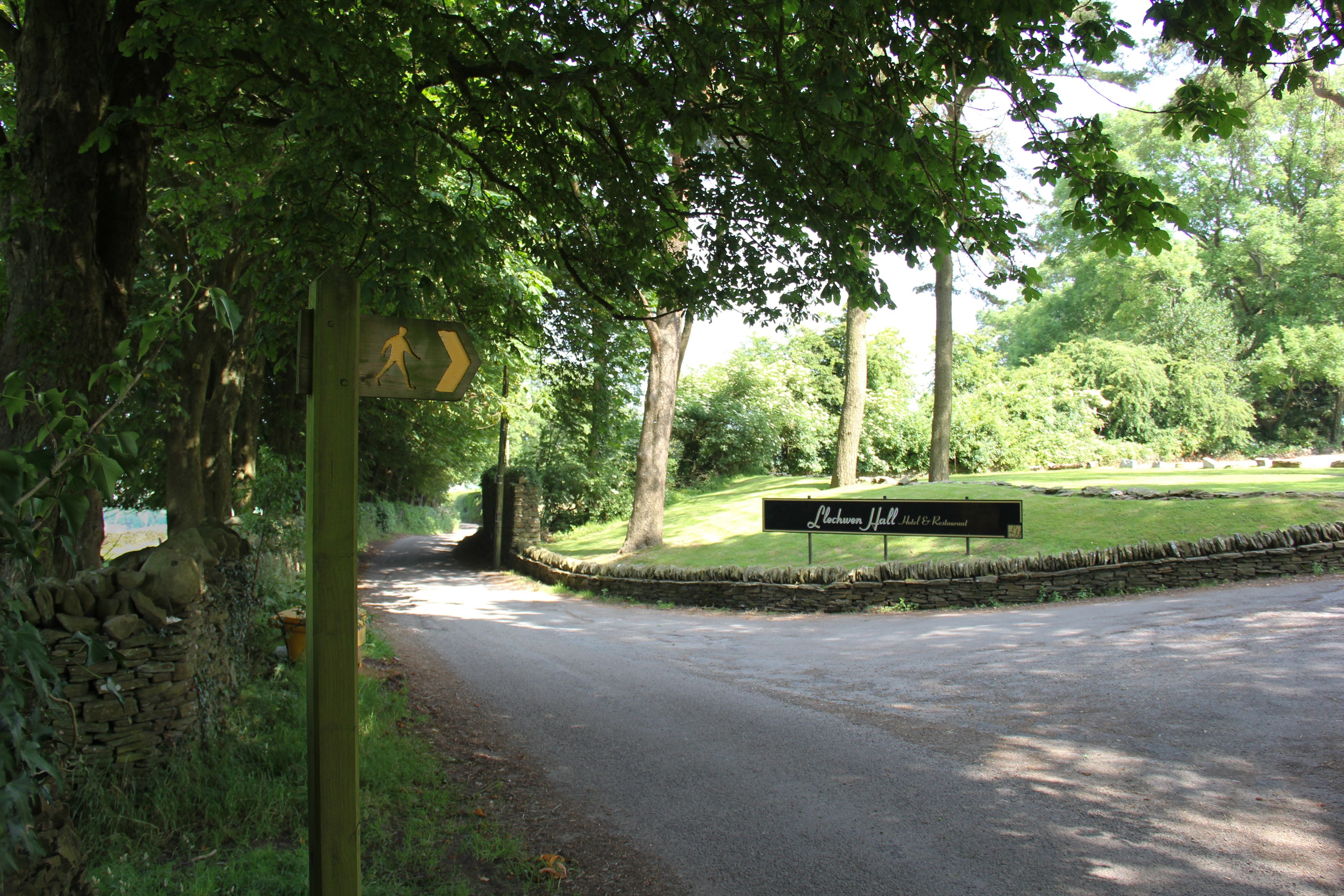 A signpost with a walking figure and a sign for 'Lechuan Hall to Restaurant'.