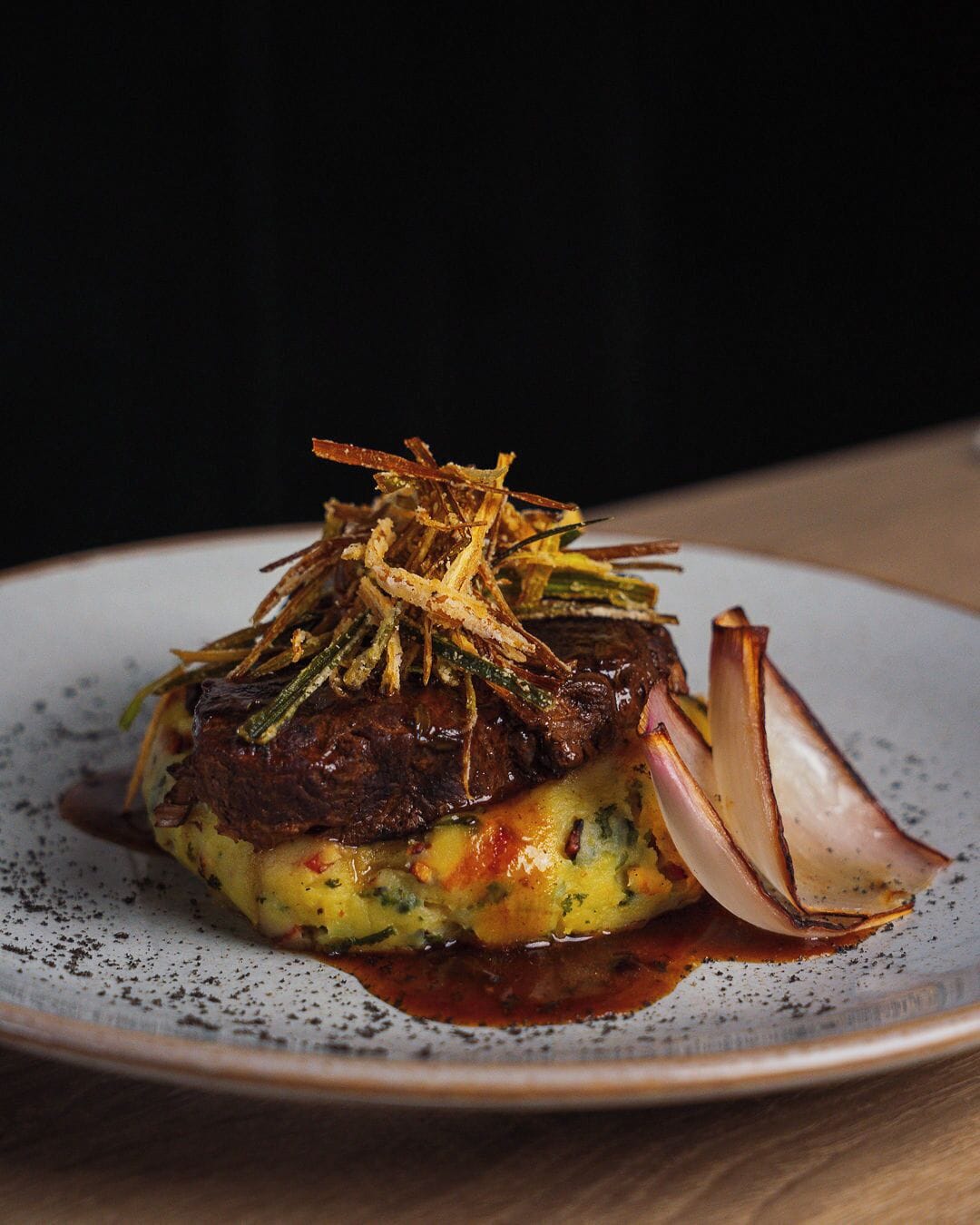 Un plato con carne, verduras y decoración.