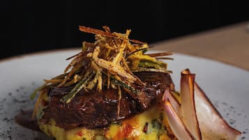 Ein angerichteter Teller mit einem Steak, Gemüse und Garnitur.