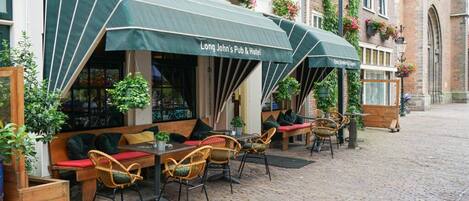 Outdoor seating with green awnings at Long John's Pub & Hotel.