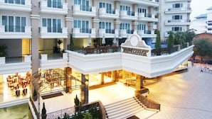 Hotel com vários andares, átrio central, varandas e áreas de estar ao ar livre.