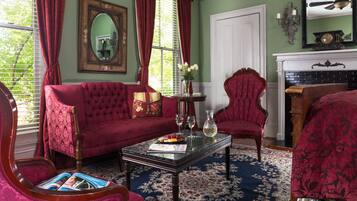 A room with a red sofa, a matching armchair, a coffee table, and a fireplace.