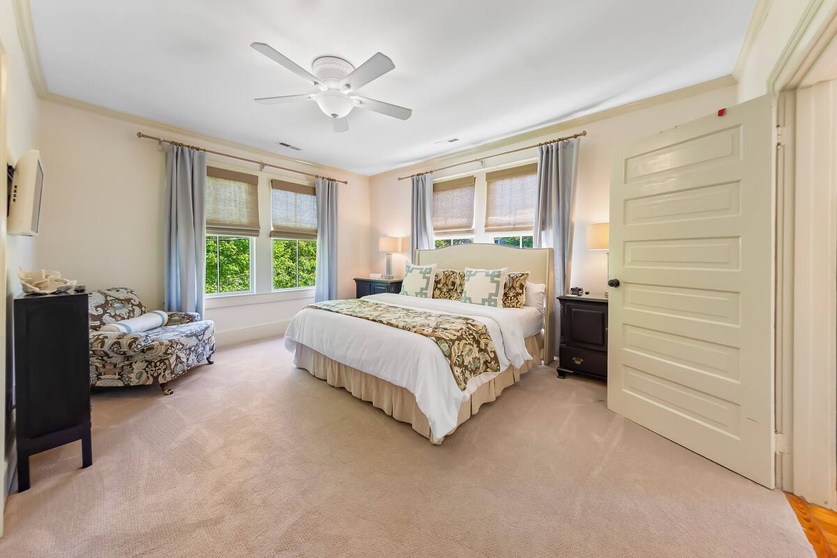 Een slaapkamer met een bed, een stoel, een nachtkastje, een kledingkast en een deur.