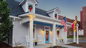 Une maison avec un porche, une porte bleue et des drapeaux américains.