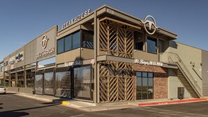 A steakhouse with a modern design, featuring a prominent logo, multiple windows, and a fire escape.