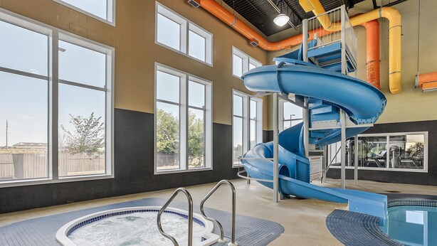 Ein großer Wasserpark mit Whirlpool, Wasserrutsche und Schwimmbecken.