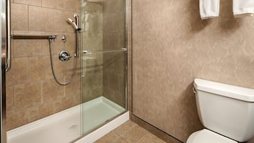 A bathroom with a glass-enclosed shower, a bathtub, and a toilet.